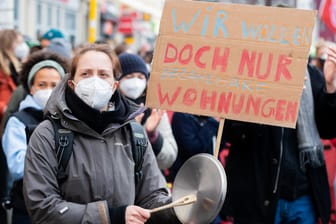Eine Frau mit Kochtopfdeckel und einem Schild nimmt an einer Demonstration: Auf dem Schild steht "Wir wollen doch nur bezahlbare Wohnungen".