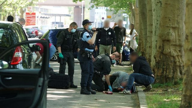 Polizisten betreuen einen verletzten Mann
