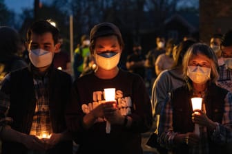 Menschen halten Kerzen in der Hand (Symbolbild): Von Freitag bis Sonntag soll den fast 80.000 Corona-Toten in Deutschland gedacht werden.