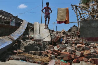 Ein Junge auf den Trümmern eines durch einen Zyklon zerstörten Hauses in Bangladesch: Die Krisen überlagern sich.