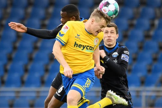 Braunschweigs Felix Kroos (M) kommt gegen Aristote Nkaka (l) und Ron Schallenberg vom SC Paderborn zum Kopfball.