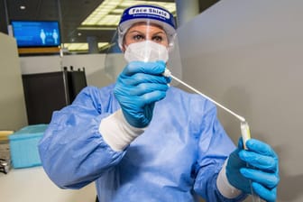 Eine Helferin bereitet einen Corona-Test vor. In Deutschland gehen die Infektionszahlen weiter nach oben.