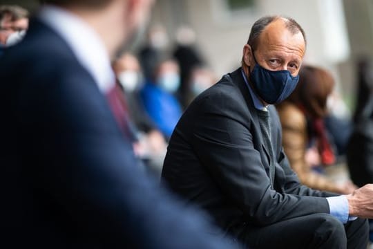 Friedrich Merz (CDU), ehemaliger Vorsitzender der Unions-Fraktion im Bundestag, sitzt auf der Tribüne des Stadions Große Wiese.