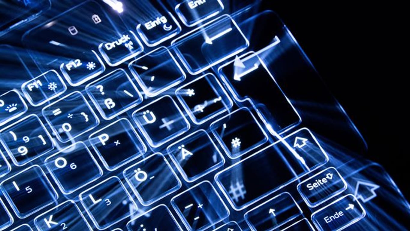 Eine leuchtende Tastatur (Symbolbild): Die Zahl der Cyberattacken auf Firmen steigt - und deutsche Betriebe sind besonders betroffen.