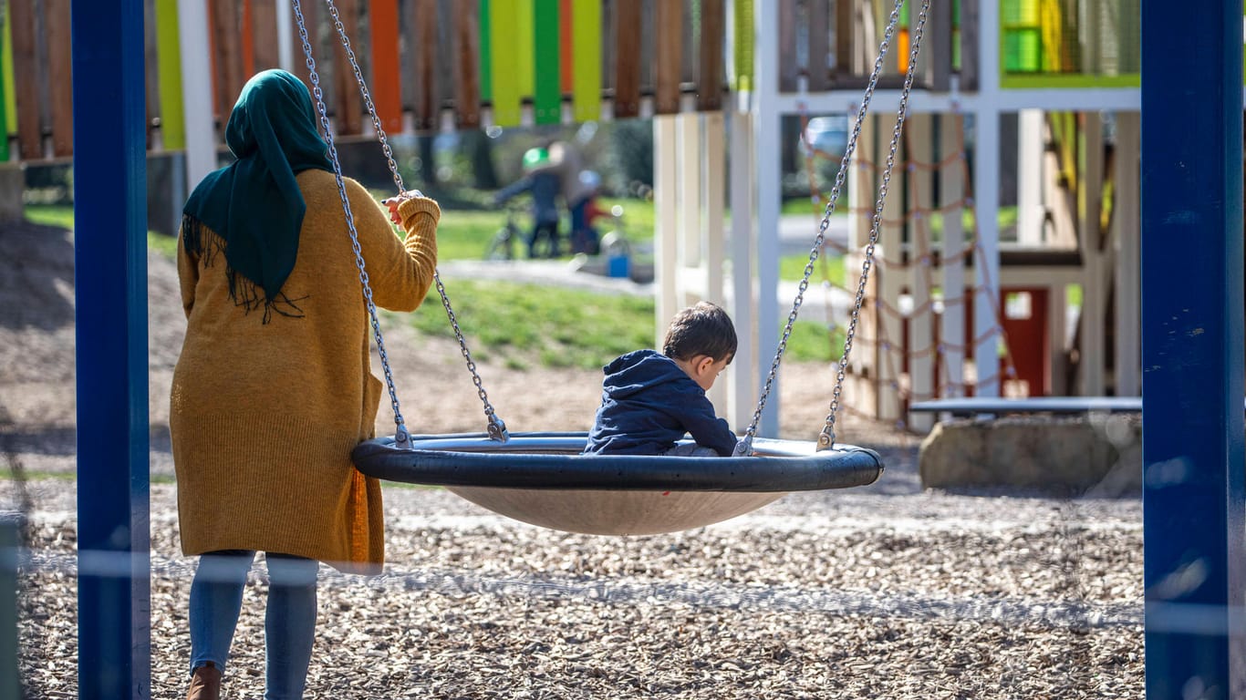 Eine Mutter spielt mit ihrem Sohn auf einem Spielplatz (Symbolbild): In Köln hat eine 28-Jährige auf einem Spielplatz bis zu 15 Zentimeter lange Glasscherben gefunden.