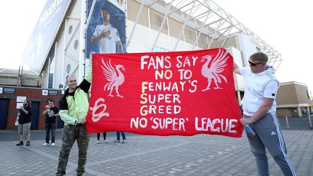 Fußball-Fans protestieren vor einem Spiel der Premier League: "Fans Say No To Fenway's Super Greed - No 'Super' League". Fußball-Fans protestieren vor einem Spiel der Premier League: "Fans Say No To Fenway's Super Greed - No 'Super' League".