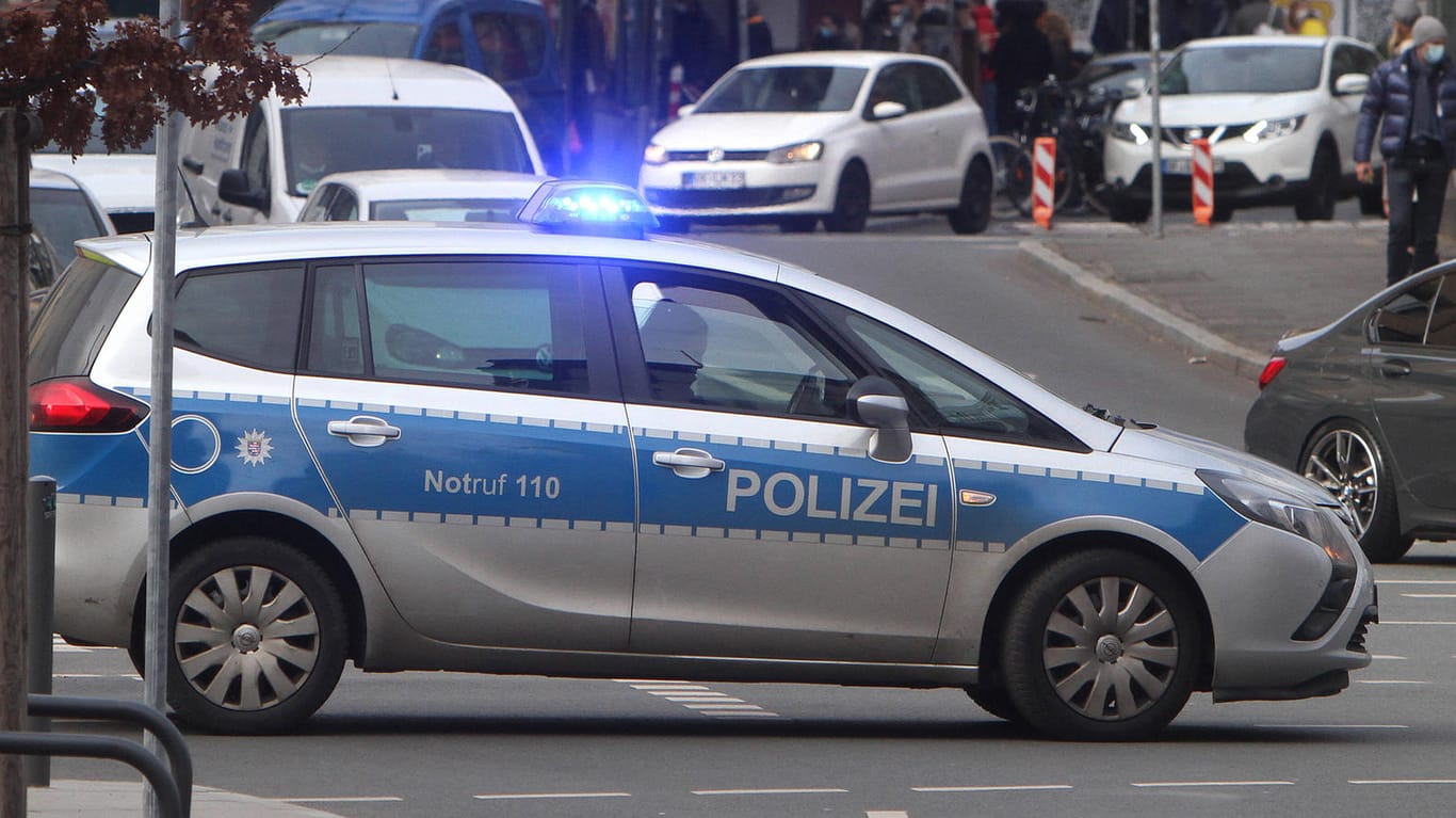Ein Einsatzwagen der Polizei fährt mit Blaulicht auf der Berliner Straße in der Innenstadt von Frankfurt (Archivbild): Im Zusammenhang mit mehreren Gewalttaten im Bandenmilieu haben Staatsanwaltschaft und Polizei nun Durchsuchungen durchgeführt.