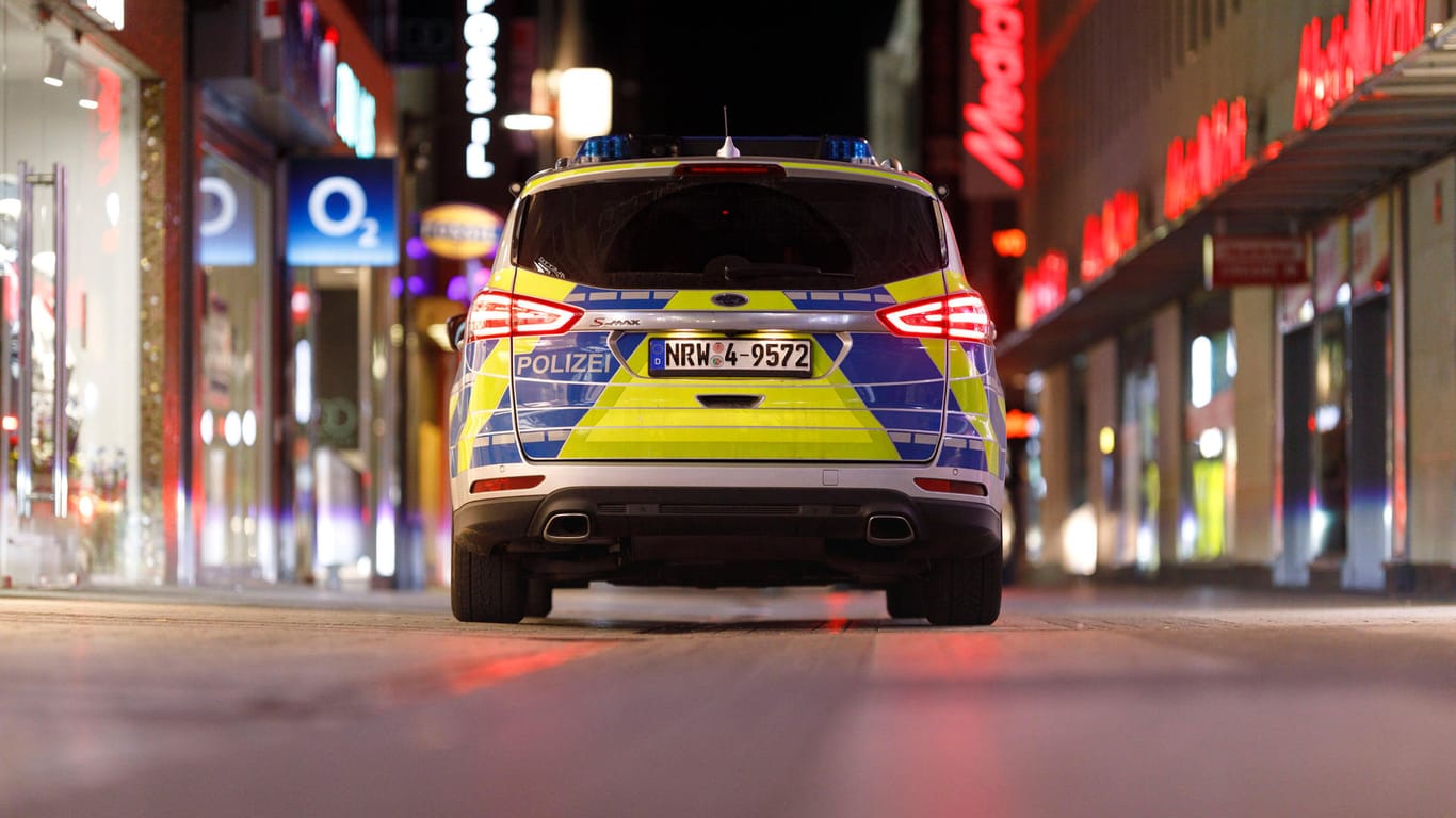 Ein Polizeiwagen fährt nachts durch die verlassene Hohe Straße: Die Ausgangsbeschränkungen in Köln bleiben. Das Verwaltungsgericht hat Eilanträge gegen die Maßnahme abgewiesen.