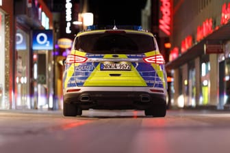 Ein Polizeiwagen fährt nachts durch die verlassene Hohe Straße: Die Ausgangsbeschränkungen in Köln bleiben. Das Verwaltungsgericht hat Eilanträge gegen die Maßnahme abgewiesen.
