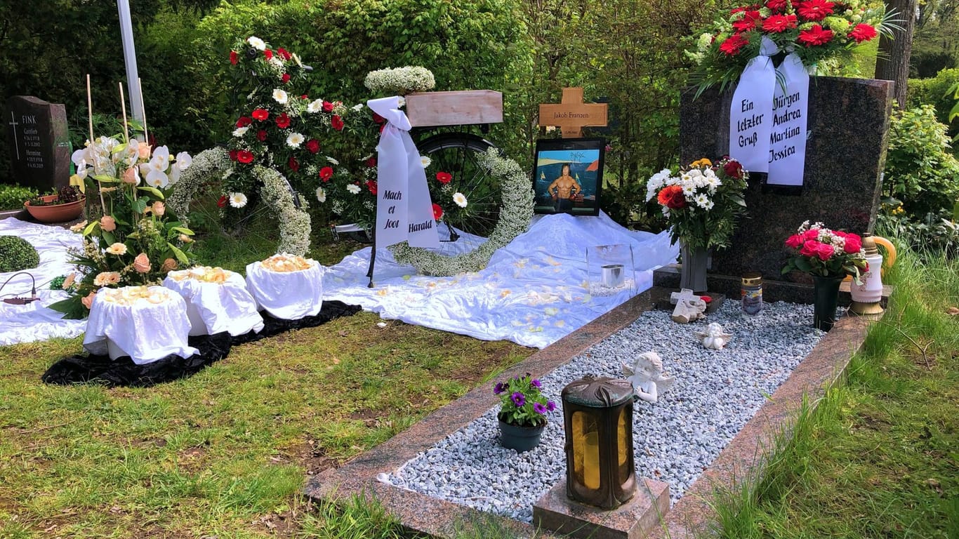 "Mache et jot" steht auf einem Trauergebinde: Das Urnengrab von "Karate Jacky" auf dem Kölner Westfriedhof.