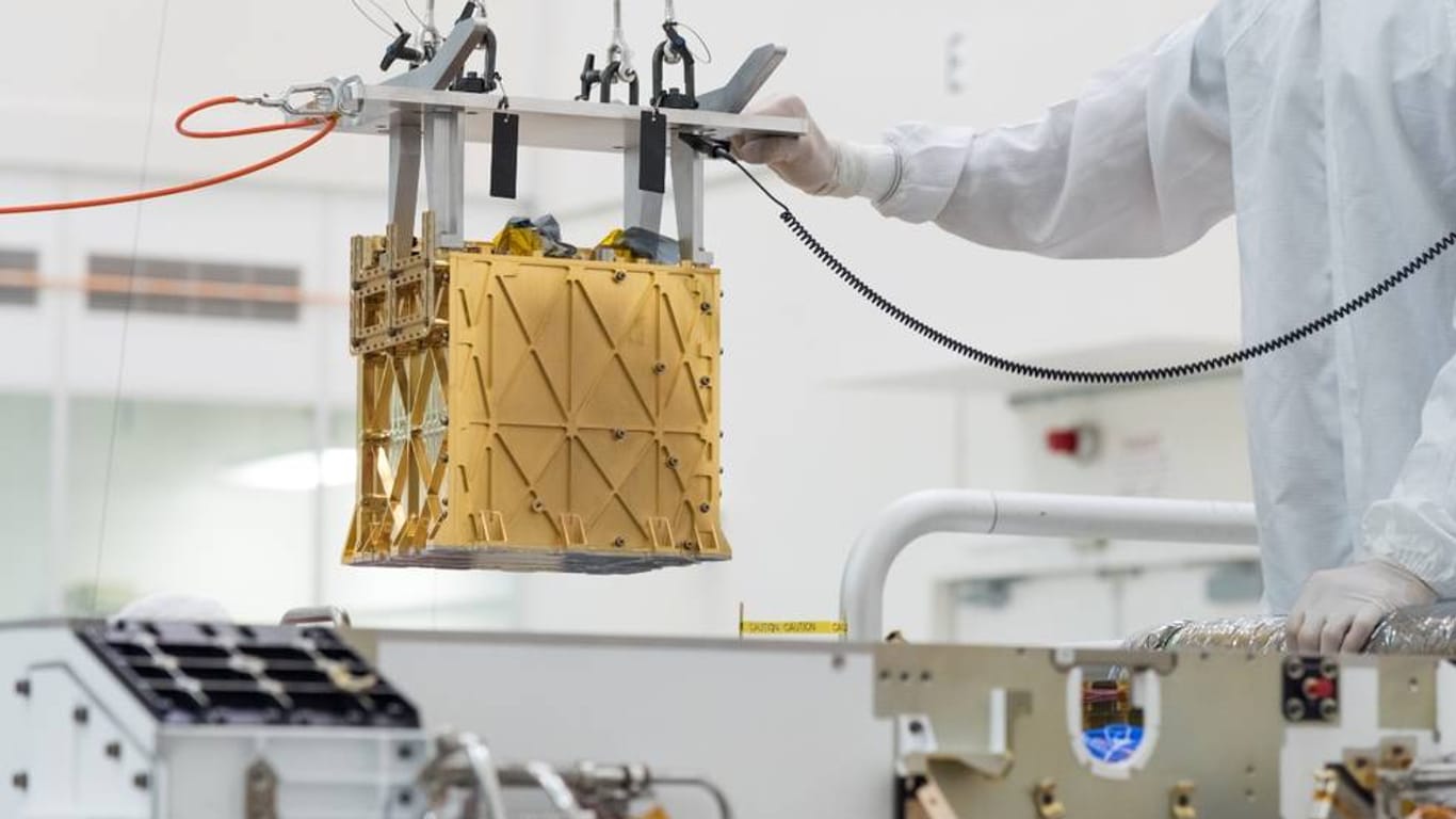 Techniker in einem Nasa-Labor führen das wissenschaftlichen Gerät namens "Moxie" in das Innere des Mars-Rovers ein: "Perseverance" hat auf dem Mars erstmals Sauerstoff extrahiert.