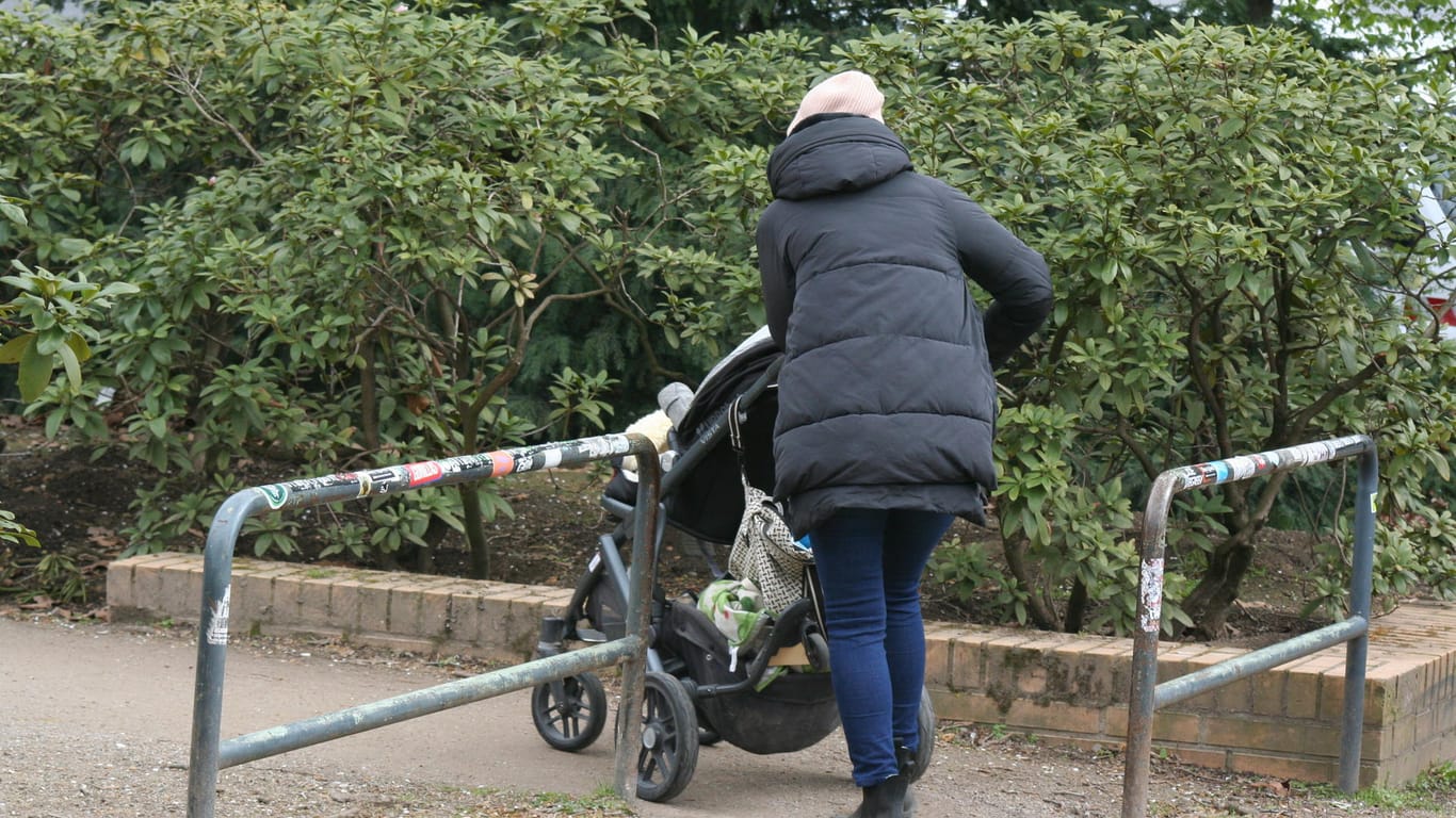 Eine Frau geht mit ihrem Kinderwagen durch eines der Drängelgitter: Eine Kölner Ratsgruppe ärgert sich über die "künstlichen Hindernisse".