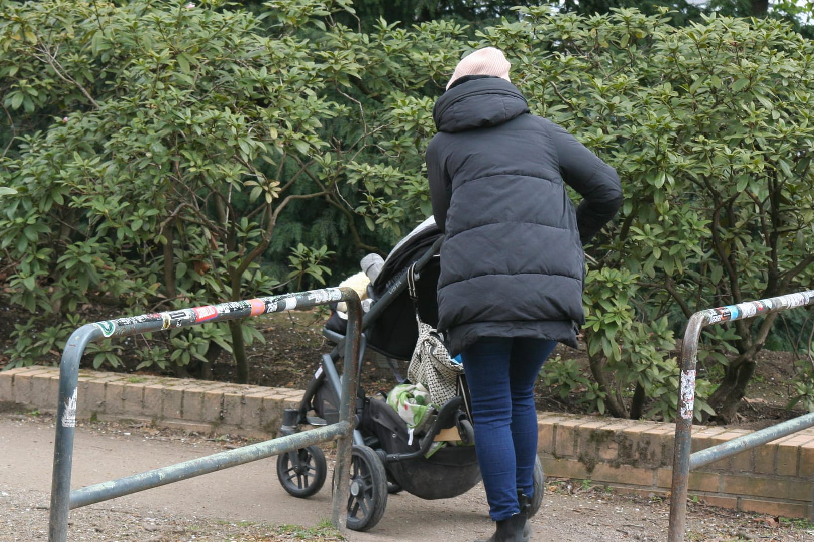 Eine Frau geht mit ihrem Kinderwagen durch eines der Drängelgitter: Eine Kölner Ratsgruppe ärgert sich über die "künstlichen Hindernisse".