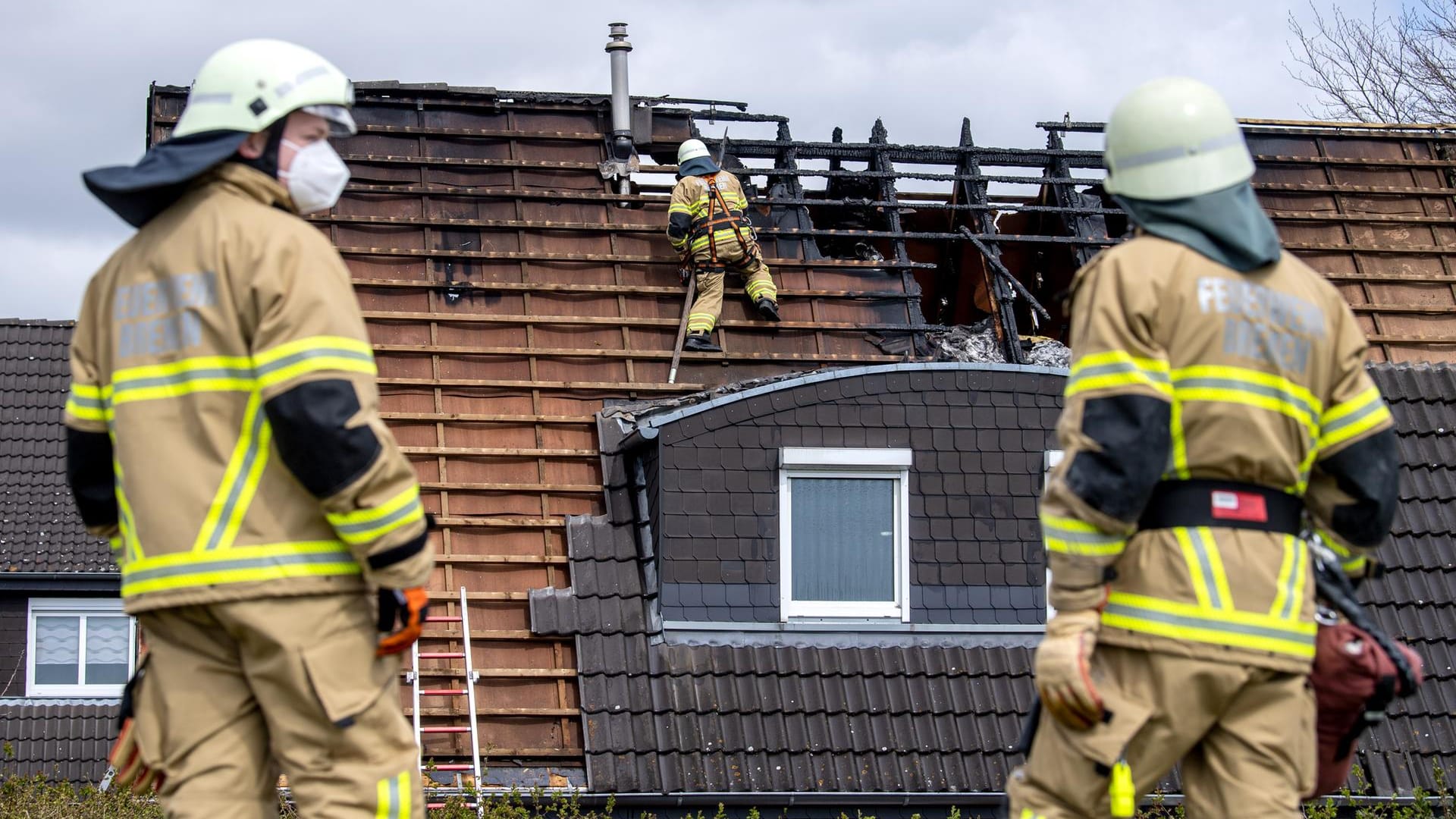 Einsatzkräfte der Feuerwehr stehen vor einem durch Feuer beschädigten Haus im Stadtteil Mahndorf: Beim Brand eines Einfamilienhauses in Bremen sind vier Menschen getötet worden. Einsatzkräfte der Feuerwehr stehen vor einem durch Feuer beschädigten Haus im Stadtteil Mahndorf: Beim Brand eines Einfamilienhauses in Bremen sind vier Menschen getötet worden.