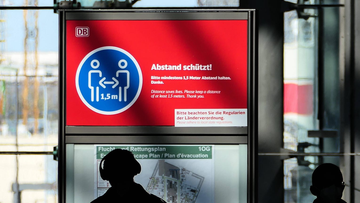 Passanten im Berliner Hauptbahnhof laufen an einem Hinweisschild zum Abstandhalten vorbei (Symbolbild): In Berlin sollen die Corona-Fälle künftig anders gezählt werden.