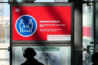 Passanten im Berliner Hauptbahnhof laufen an einem Hinweisschild zum Abstandhalten vorbei (Symbolbild): In Berlin sollen die Corona-Fälle künftig anders gezählt werden.