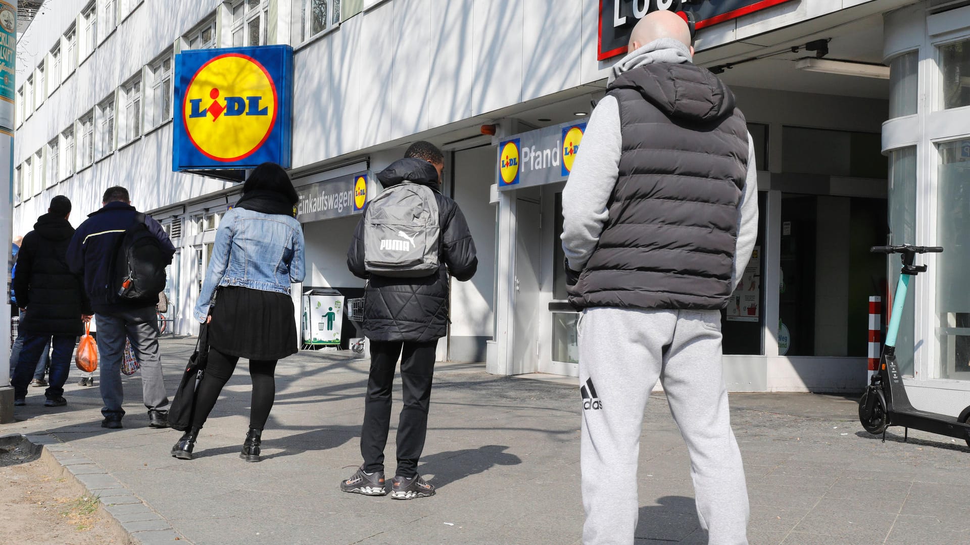 Kunden warten vor einem Lidl (Symbolbild): Es gilt eine Bundesnotbremse.