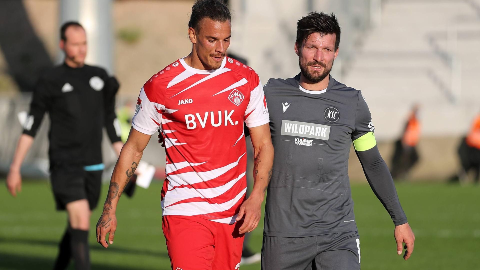 KSC-Kapitän Jerome Gondorf (r.) mit aufmunternden Worten für Würzburgs Rolf Feltscher.