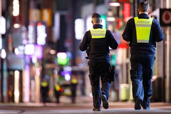 Polizisten laufen in Köln Streife (Archivbild). In vielen Städten gibt es seit Samstag eine nächtliche Ausgangssperre.