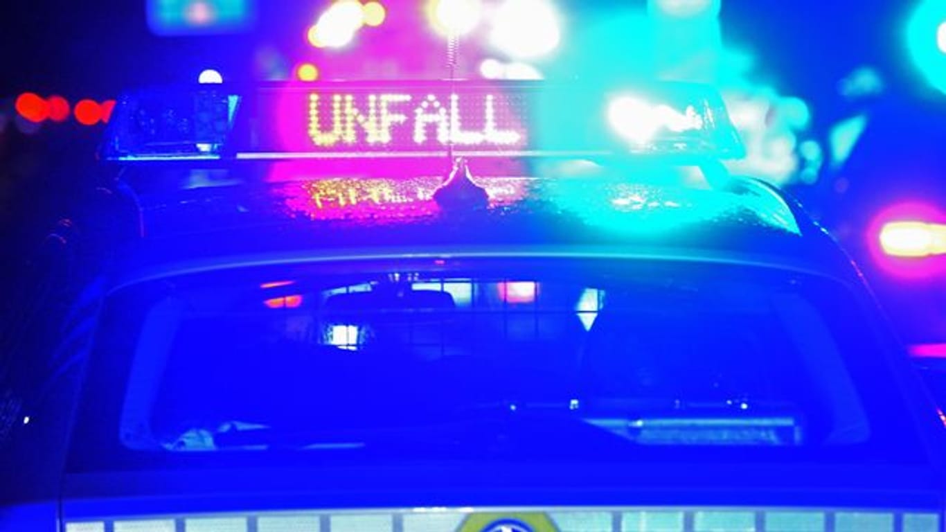 Ein Polizeiwagen steht mit eingeschaltetem Blaulicht an einer Unfallstelle (Symbolbild): Ein 35-jähriger Autofahrer übersah eine Straßenbahn und krachte mit ihr zusammen.