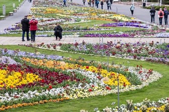 Besucher der Bundesgartenschau gehen über das Gelände auf dem Egapark: Trotz in Kraft getretener Bundesnotbremse sind die Außenbereiche der Buga geöffnet.