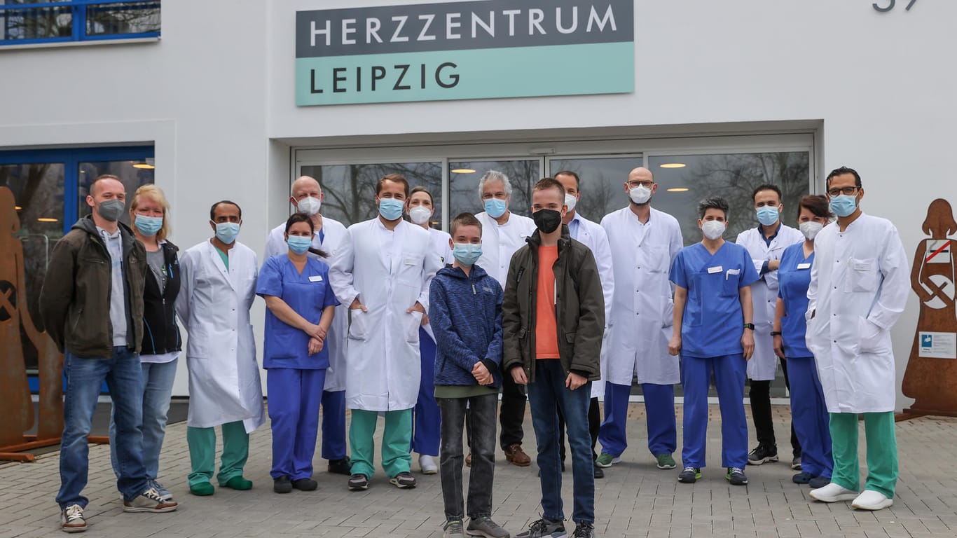 Die Zwillinge Jamie und Kilian stehen mit dem Team der Kinderherzchirurgie stehen vor dem Herzzentrum Leipzig: Mit einem anonymen Brief will sich die Familie bei den Hinterbliebenen der Spender bedanken.