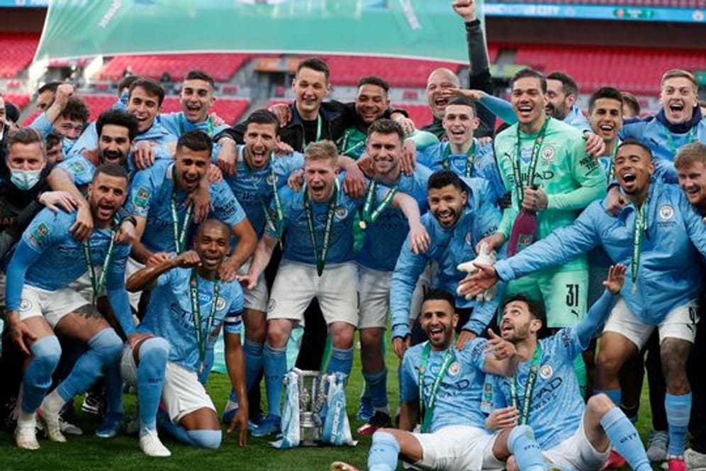 Die Spieler von Manchester City lassen sich mit dem Liga-Pokal fotografieren.