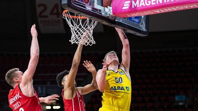 Leon Radosevic (l-r) und Jason George von Bayern München versucht Ben Lammers von Alba Berlin am Korb zu blocken. Leon Radosevic (l-r) und Jason George von Bayern München versucht Ben Lammers von Alba Berlin am Korb zu blocken.