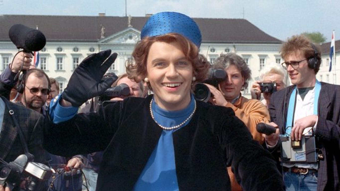 Verkleidet als Königin Beatrix der Niederlande winkt der Komiker Hape Kerkeling vor Schloss Bellevue für die Presse (1991).