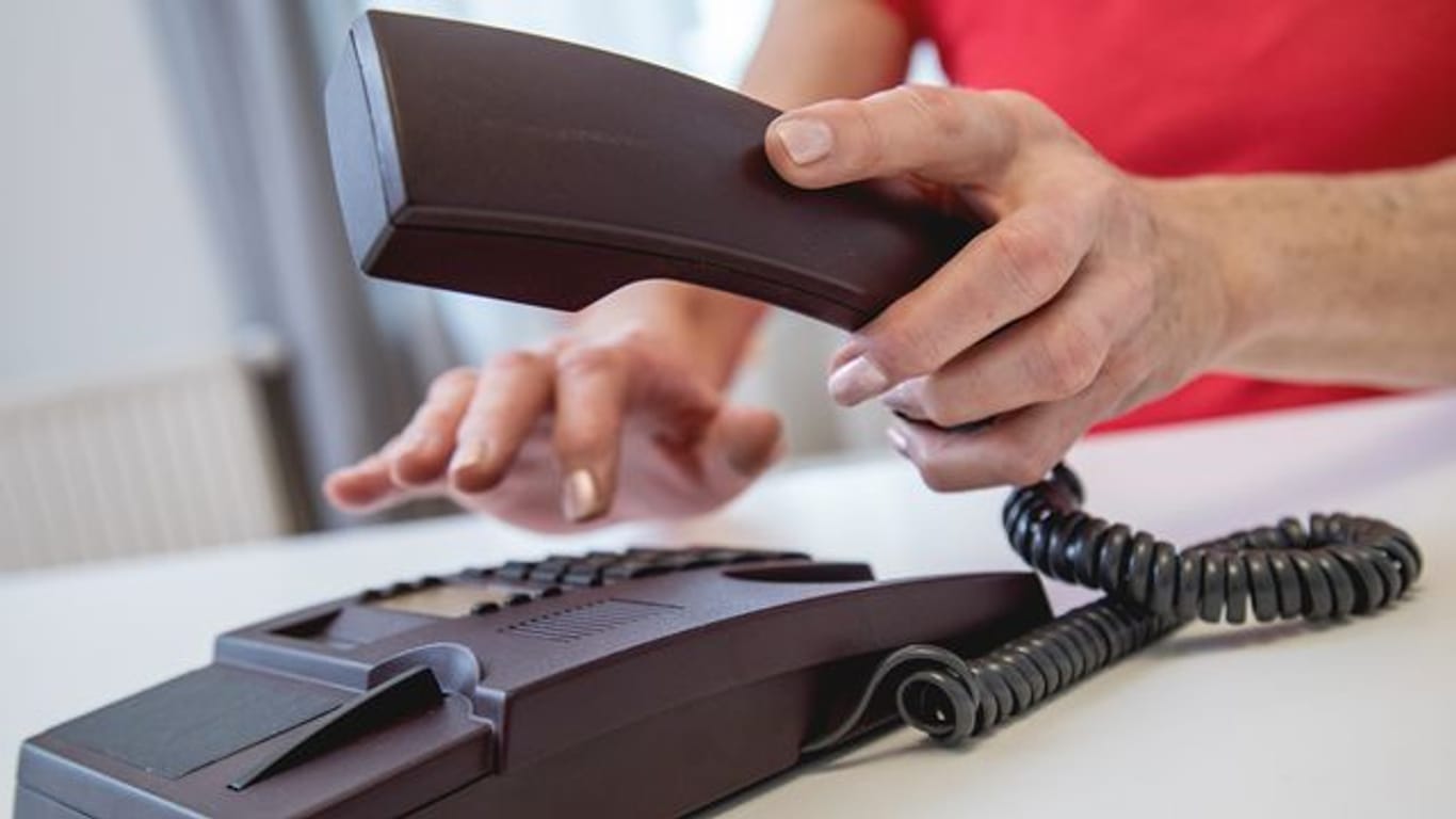 Jemand wählt eine Telefonnummer: Ein Anruf bei der Servicehotline darf für Kundinnen und Kunden nicht teurer sein als ein ganz gewöhnlicher Anruf.