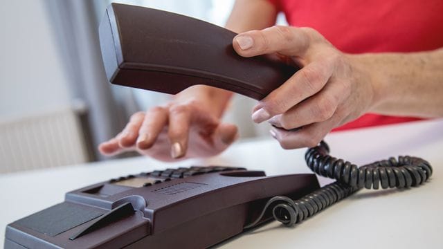 Jemand wählt eine Telefonnummer: Ein Anruf bei der Servicehotline darf für Kundinnen und Kunden nicht teurer sein als ein ganz gewöhnlicher Anruf. Jemand wählt eine Telefonnummer: Ein Anruf bei der Servicehotline darf für Kundinnen und Kunden nicht teurer sein als ein ganz gewöhnlicher Anruf.