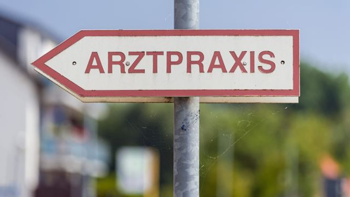 Ein Schild mit der Aufschrift "Arztpraxis" steht an der Straße (Symbolbild): Für Menschen zwischen 60 und 69 Jahren kann das Vakzin von Astrazeneca zur Impfung verwendet werden.