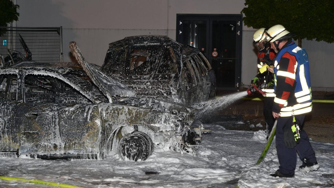 Feuerwehrmänner löschen brennende Autos (Symbolbild): Auf einem Bonner Schrottplatz löschte die Feuerwehr in der Nacht alte Autos, Metallteile und Kunststoffe.