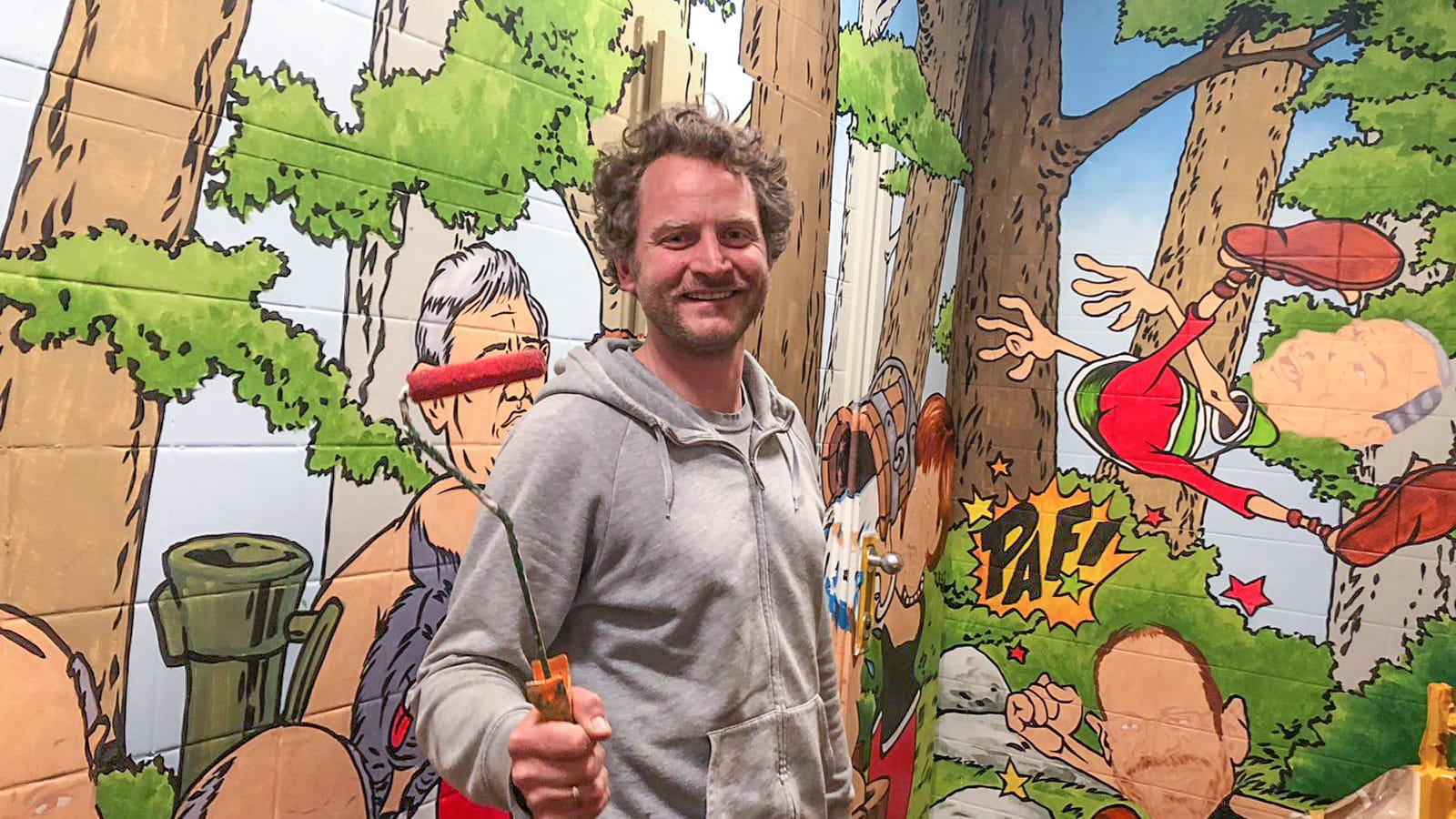 Künstler Thomas Klukas beim Bemalen der Toilettenwände.