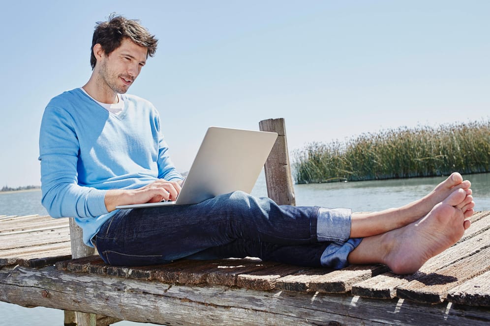 Ein Mann sitzt mit dem Laptop am See: Telefónica/O2 hat neue "Internet to Go"-Tarife im Angebot.