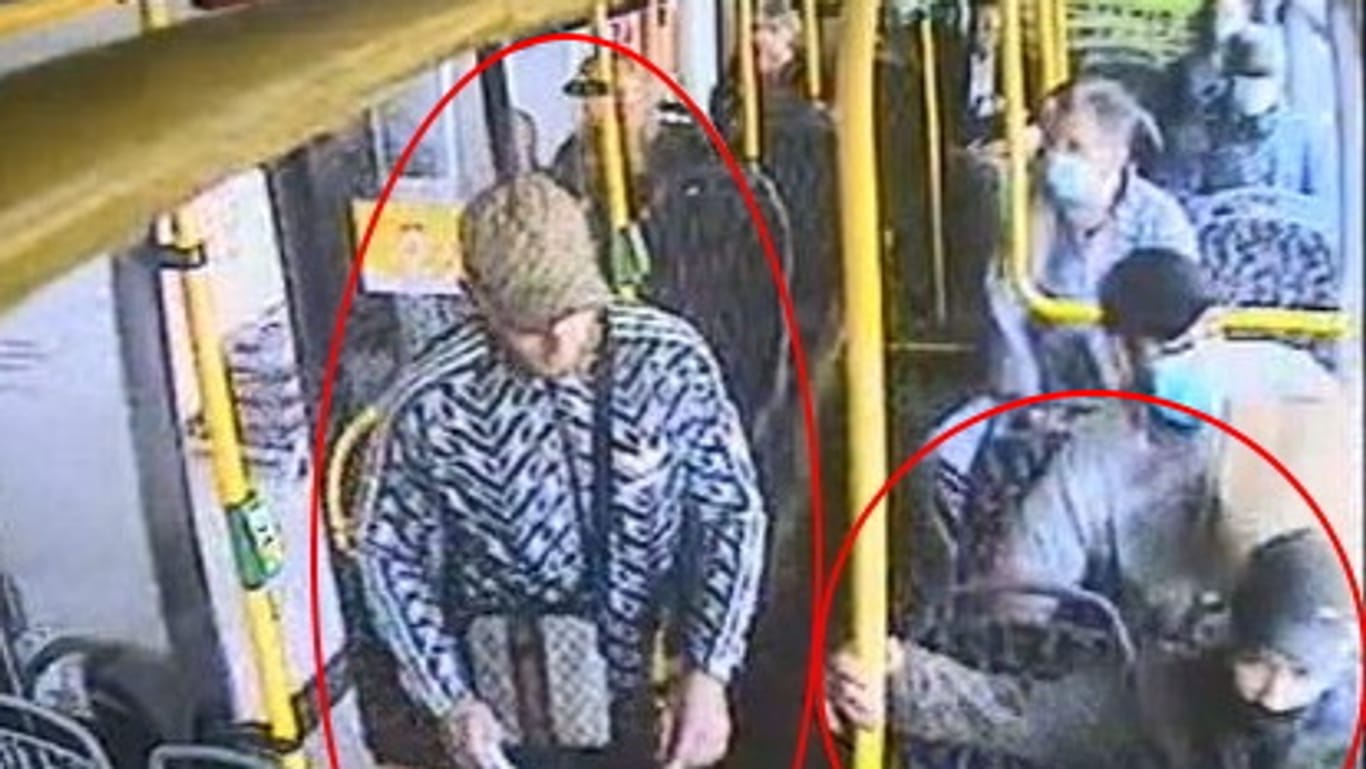 Zwei Männer in einem Bus in Berlin: Der Mann mit dem auffällig gemusterten Blouson soll einer Seniorin versucht haben, die Halskette zu rauben.