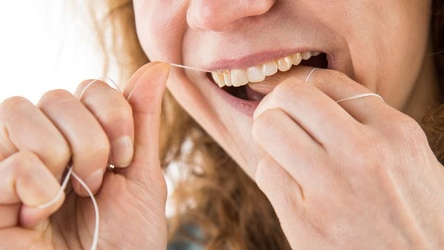 Zahnseide benutzen: Mit Vorsicht die Zahnflächen entlanggleiten – so lautet die Grundregel.