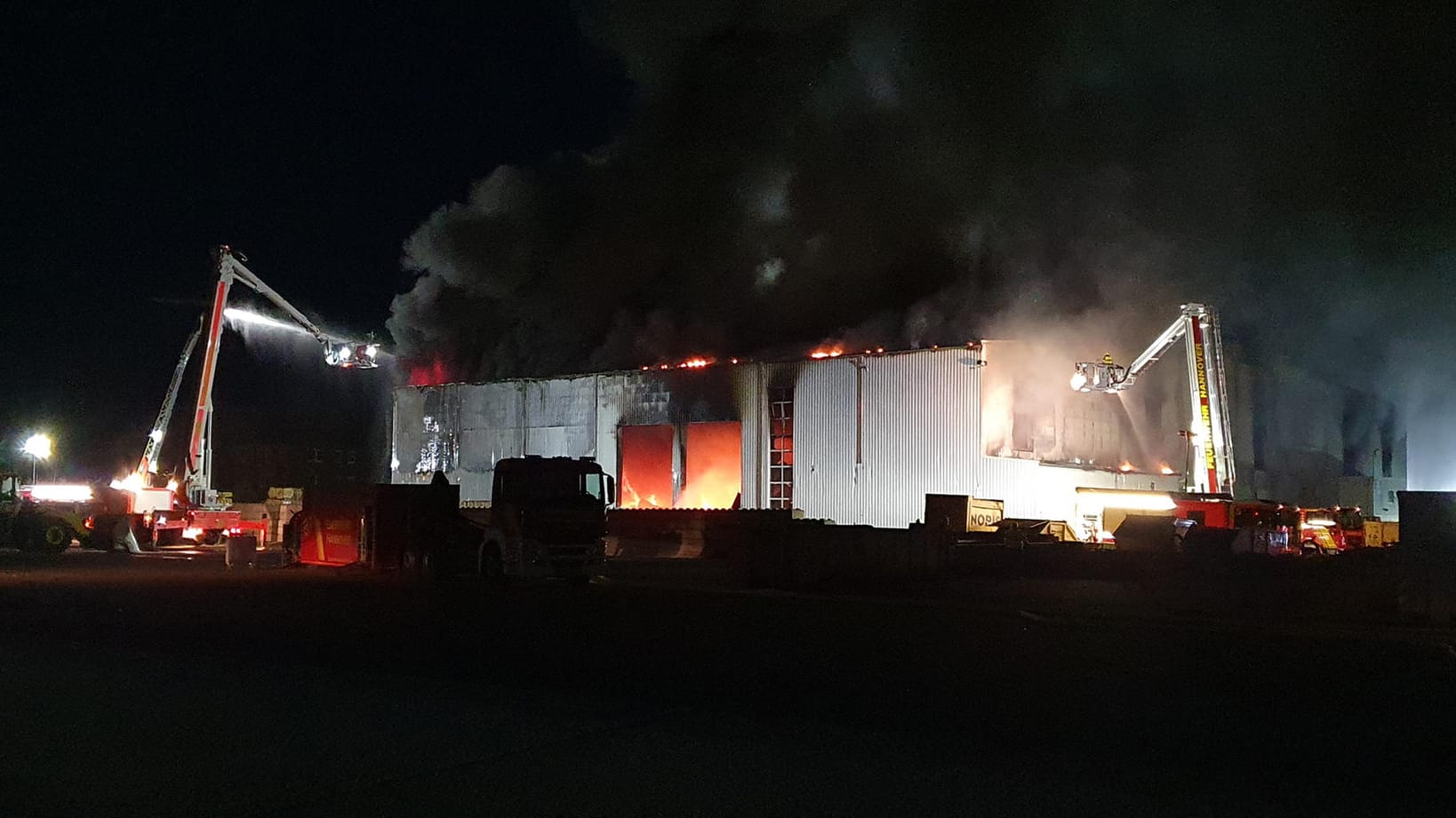 Einsatzkräfte der Feuerwehr sind im Einsatz an einer Lagerhalle: Das Gebäude stand im Vollbrand. Einsatzkräfte der Feuerwehr sind im Einsatz an einer Lagerhalle: Das Gebäude stand im Vollbrand.