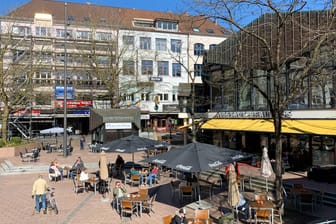 In der Kieler Innenstadt sitzen Menschen im Außenbereich eines Cafés (Symbolbild): Seit zwei Wochen dürfen die Gastronomen wieder Gäste bewirten.