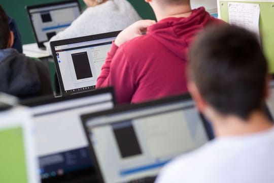 Schülerinnen und Schüler nehmen im Klassenzimmer einer 9.
