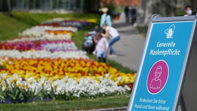 Besucher gehen in der Wilhelma an einem farbenprächtigen Tulpenbeet vorbei: Auf dem gesamten Gelände gilt Maskenpflicht. Besucher gehen in der Wilhelma an einem farbenprächtigen Tulpenbeet vorbei: Auf dem gesamten Gelände gilt Maskenpflicht.