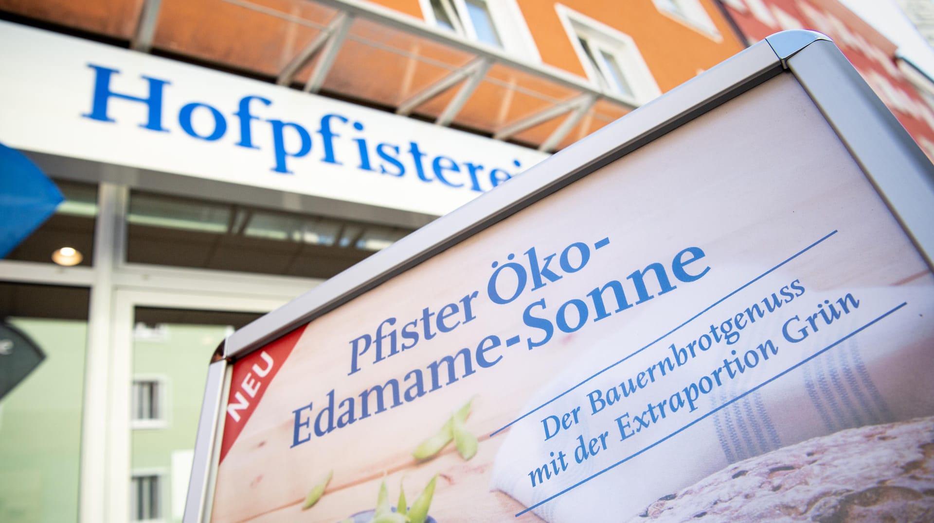 Der Schriftzug "Pfister Öko-Edame-Sonne" ist auf einer Werbetafel vor einer Bäckerei-Filiale der Hofpfisterei zu sehen: Die Bäckereikette hält die Rechte an der Marke "Sonne" und verklagt andere Anbieter, wenn zu vermuten ist, dass Markenrechte verletzt werden.
