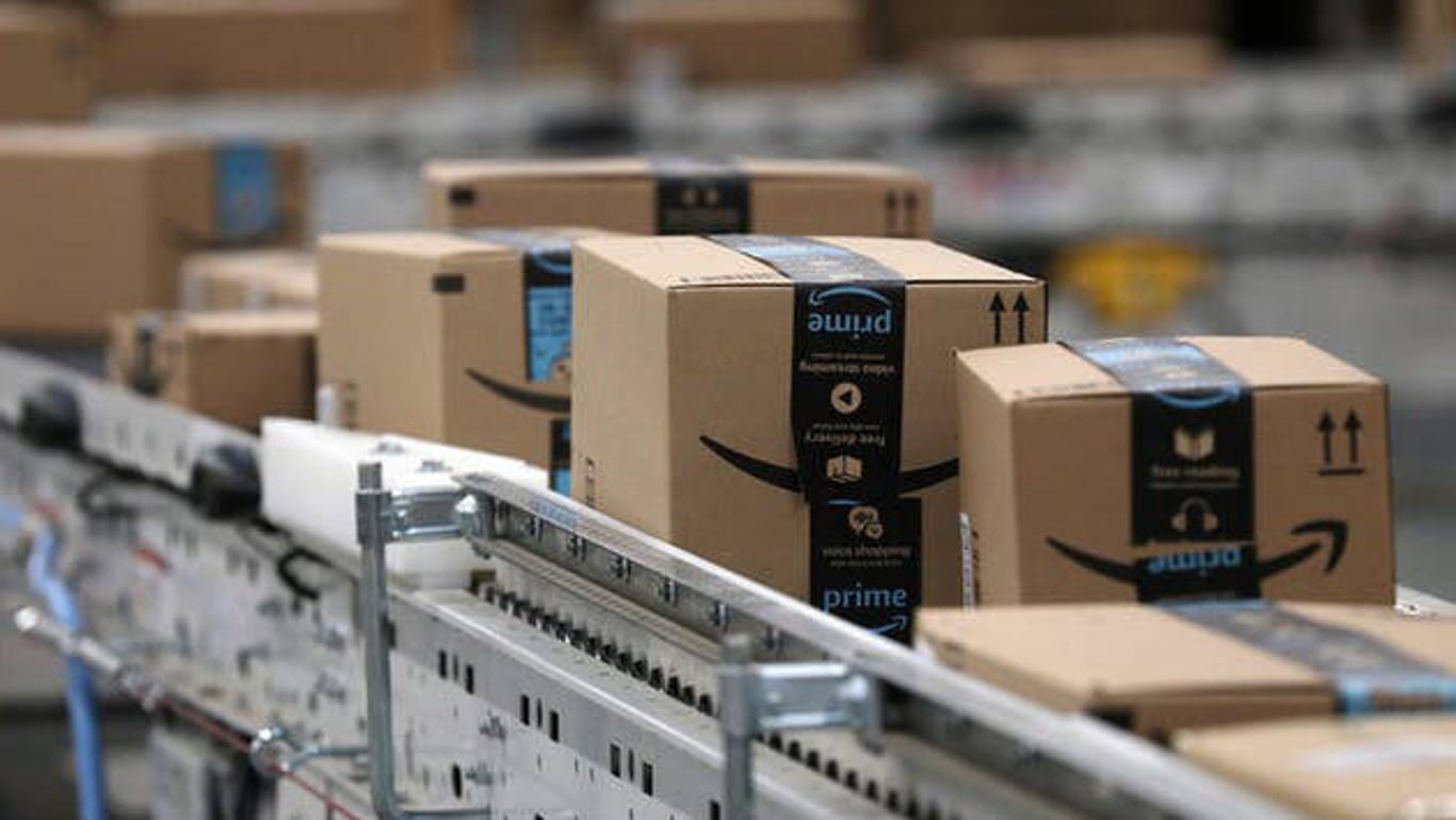 Amazon-Pakete auf Fließband (Symbolbild): Der Versandkonzern hat die Löhne angehoben.