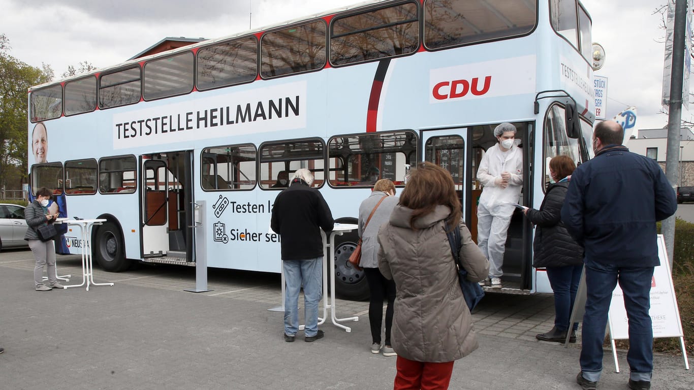 Menschen stehen vor der "Teststelle Heilmann": Den Bus stellt der CDU-Politiker Thomas Heilmann nach eigenen Angaben kostenlos zur Verfügung.