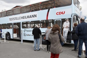 Menschen stehen vor der "Teststelle Heilmann": Den Bus stellt der CDU-Politiker Thomas Heilmann nach eigenen Angaben kostenlos zur Verfügung.
