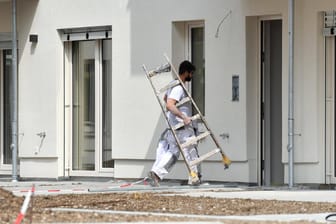 Ein Maler trägt eine Leiter (Symbolbild): Die Wirtschaftsleistung ist im ersten Quartal zurückgegangen.