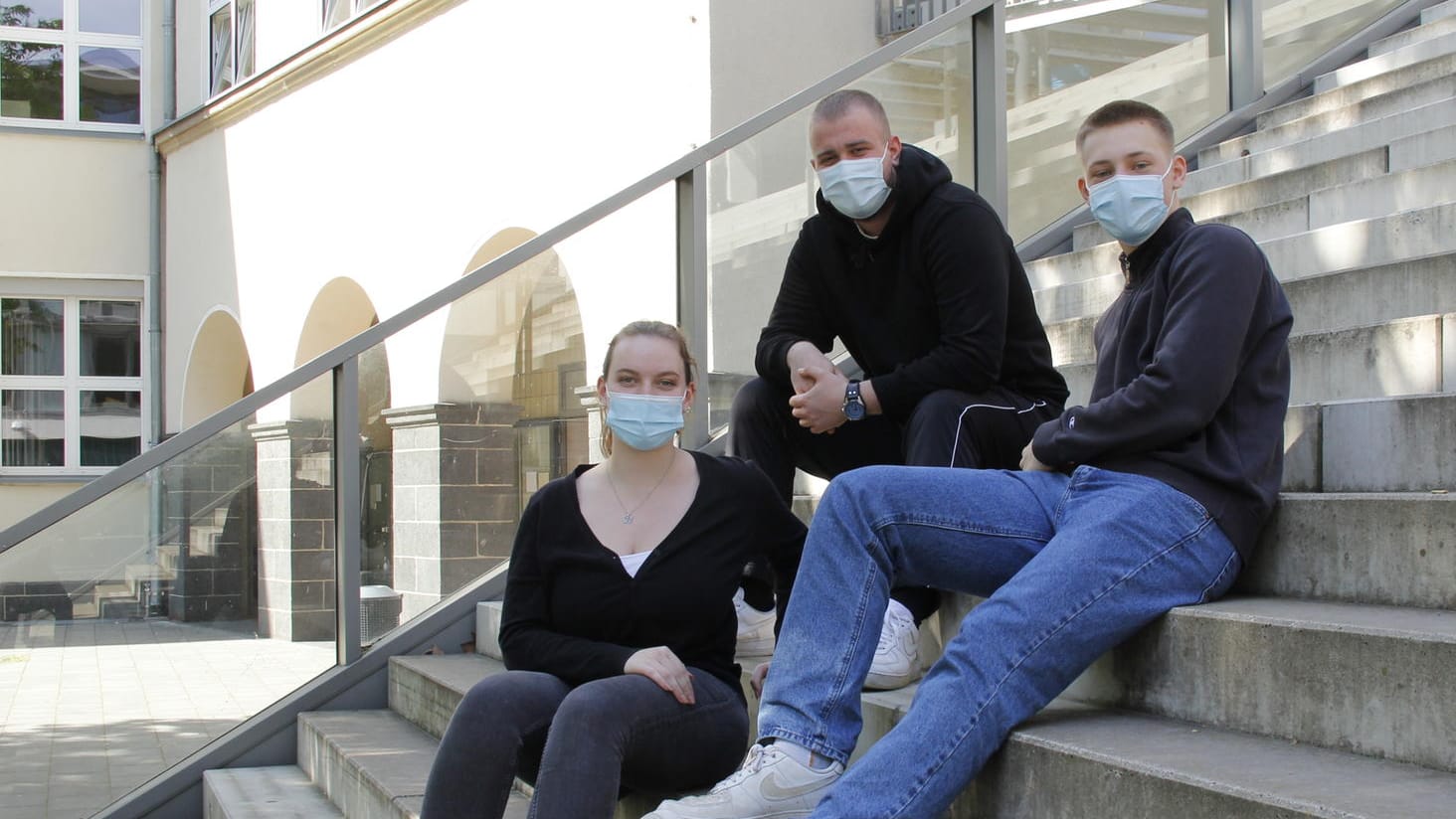 Maja Jüde mit ihren Mitschülern Nils Tromnau und Anton Glusancov auf den Stufen ihrer Schule: Sie mussten sich im April dem Abitur unter Corona-Bedingungen stellen.