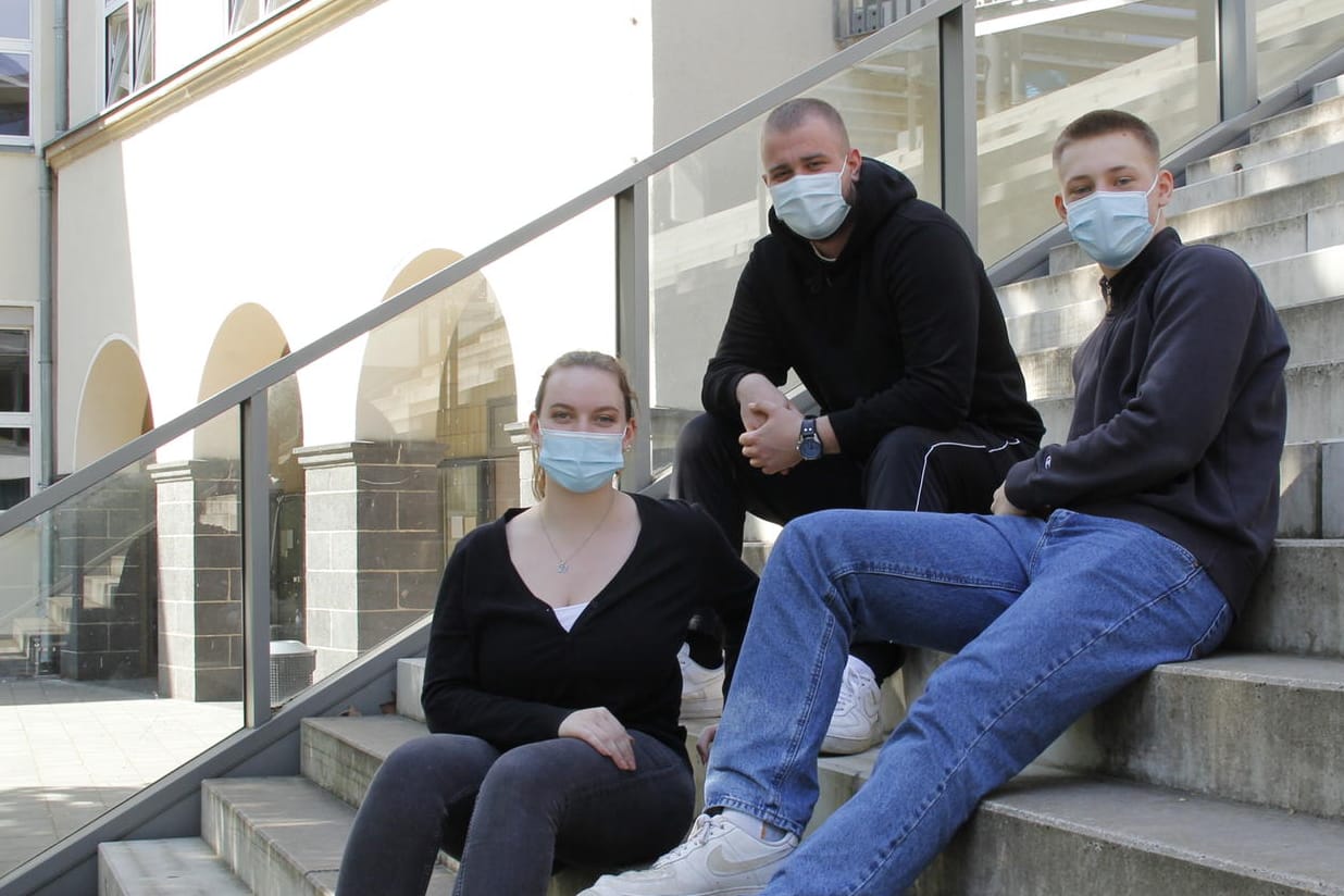 Maja Jüde mit ihren Mitschülern Nils Tromnau und Anton Glusancov auf den Stufen ihrer Schule: Sie mussten sich im April dem Abitur unter Corona-Bedingungen stellen.