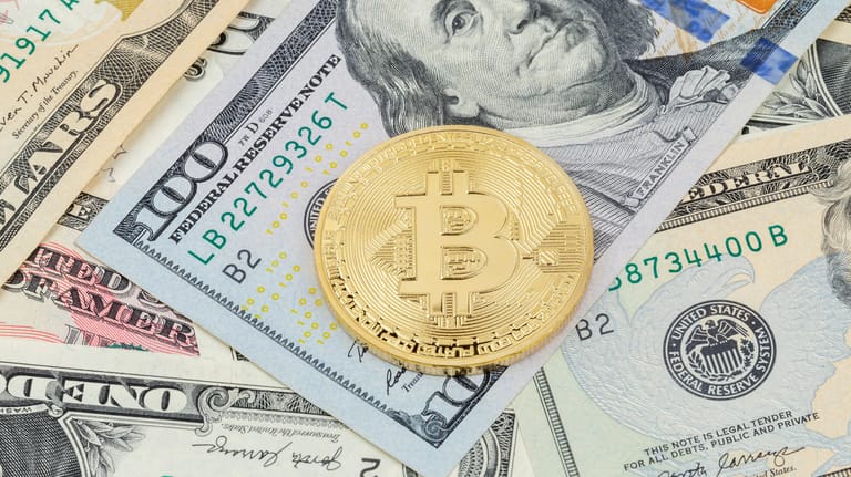 Physischer Bitcoin auf Dollarnoten: Das Finanzamt erkennt Kryptowährungen wie Bitcoins nicht als Währung an. Das hat Auswirkungen auf den Steuersatz.