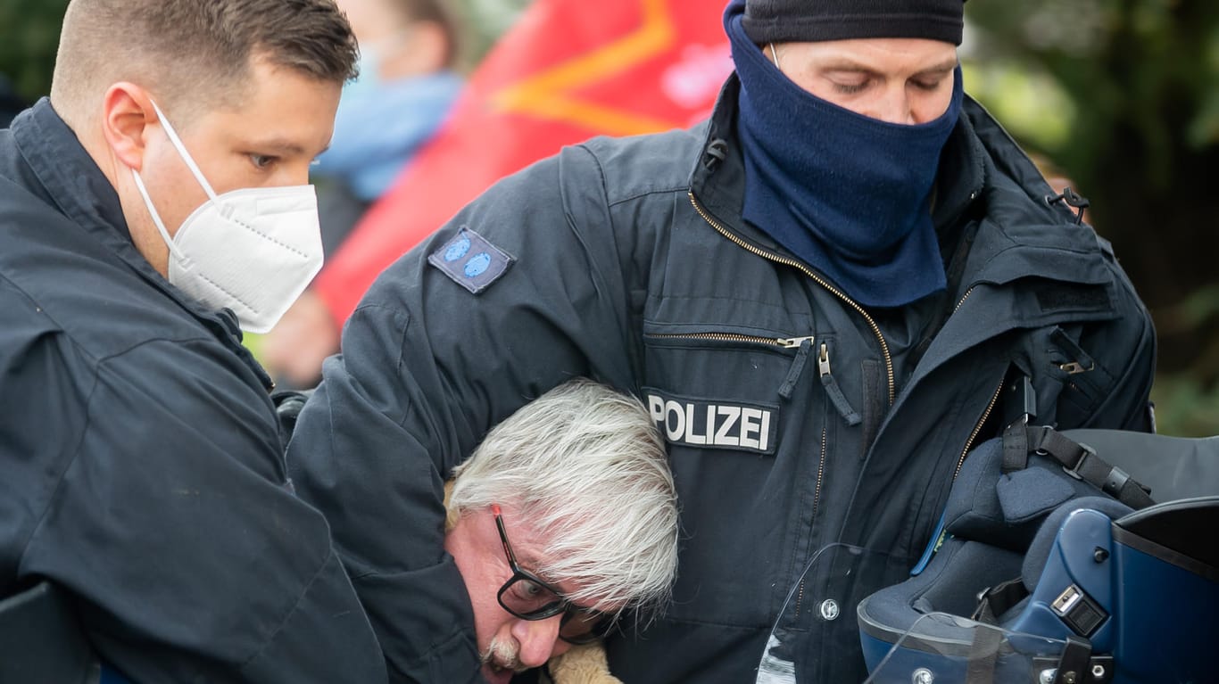 Polizisten führen bei einer Kundgebung zu Beginn einer Demonstration unter dem Motto «Nein zum Kapital - Widerstand global! Linke gegen Corona-Willkür» in Berlin-Lichtenberg einen Mann ab: In der Hauptstadt sind 5.600 Polizisten im Einsatz.